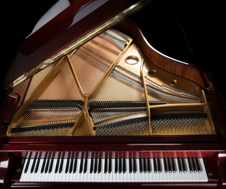 high-gloss mahogany grand piano keyboard, strings, and inside