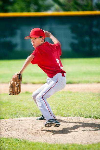 istock Youthful Male Baseball Pitcher Eyes Camera Winding Up on Moung 166076934