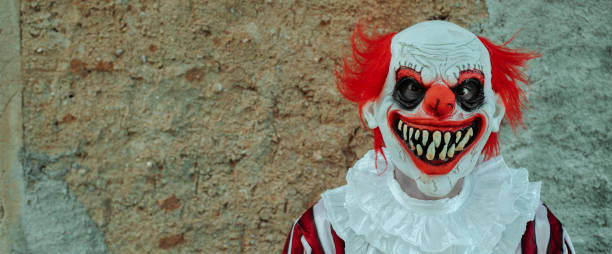 istock mad evil clown in front of a rustic house, banner 1660774846