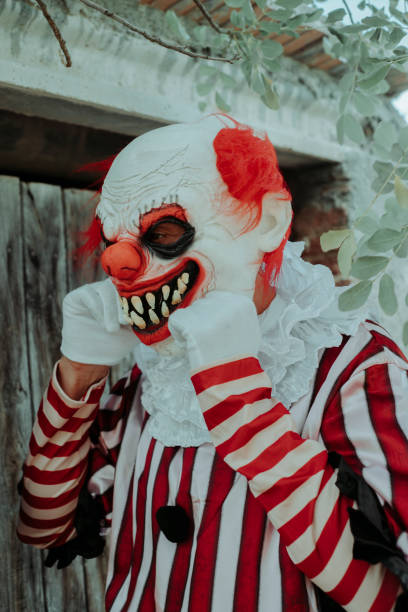 istock putting on a clown mask in front of a rustic house 1660775395
