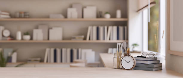 istock A wooden table with copy space over blurred minimal bright room with a bookshelf in the background. 1660801496