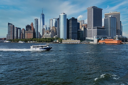 New York City, USA. July 26, 2023. Panoramia of the Manhattan Island from the Staten Island Ferry. A speedboat is in the foreground.