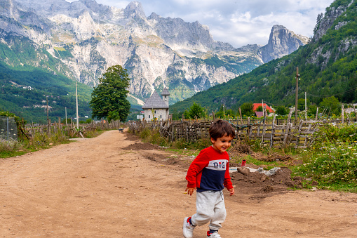 A very happy child running in the valley of Theth national park, Albania. albanian alps
