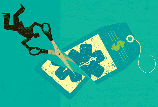 A businessman cutting the high price of healthcare tag with large scissors over an abstract background. The man, scissors and price tag are on a separate layer from the background.