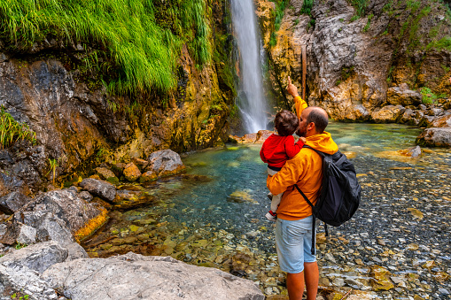 Man with his son at Grunas waterfall in Theth national park, Albania. Albanian alps