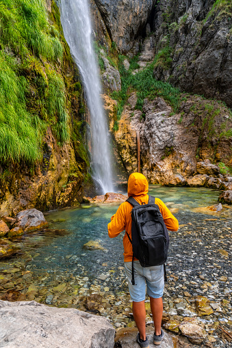 Hiker at Grunas waterfall in Theth national park, Albania. Albanian alps