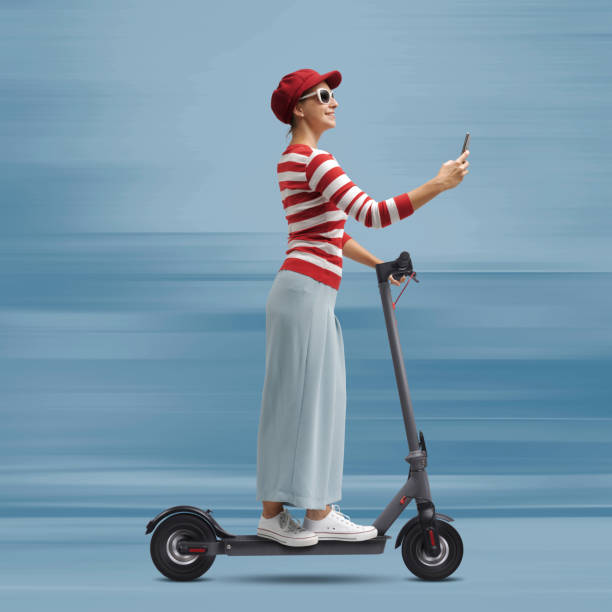 istock Woman riding a scooter and using her phone 1660852813