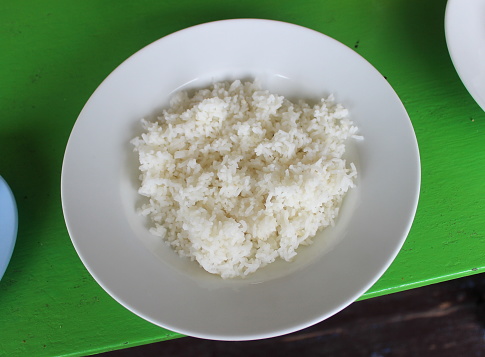 Rice on a plain white plate. This is the staple food of most people in Asia.