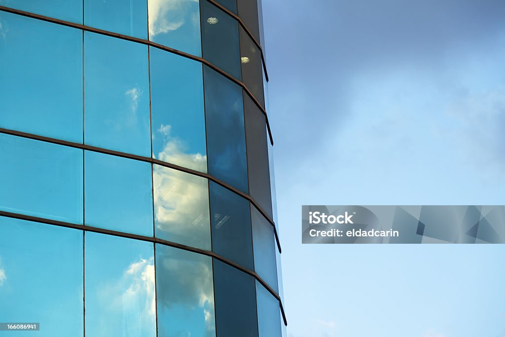 Cloudy Office Building Afternoon cloudy sky reflecting off an office building's curtain wall. Abstract Stock Photo