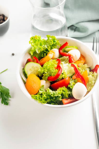 istock Bowl with salad with red and yellow tomatoes, peper, cucumbers, lettuce and mozzarella. 1660874834