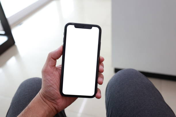 istock Hand holding phone white screen on blur background 1660895903