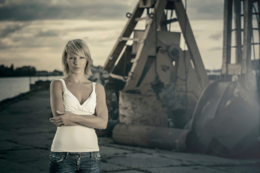 Young woman standing in front of industrial site