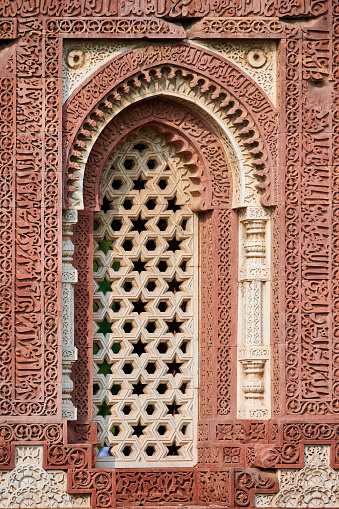 Decorative window shutters of Alai Darwaza landmark part of Qutb complex in South Delhi, India, red sandstone and inlaid white marble ancient window decorations of Alai Darwaza main gateway