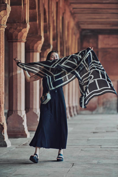 east asian woman in black dress dancing with translucent scarf among columns of ancient temple - taj mahal mahal door temple imagens e fotografias de stock