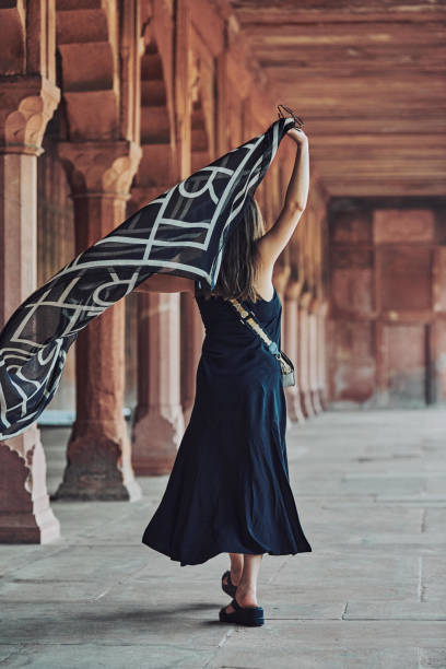 donna dell'asia orientale in vestito nero che danza con sciarpa traslucida tra le colonne del tempio antico - taj mahal mahal door temple foto e immagini stock