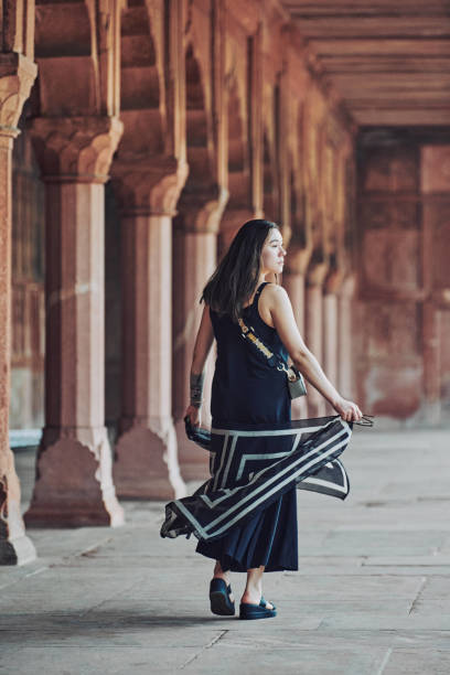 donna dell'asia orientale in vestito nero che danza con sciarpa traslucida tra le colonne del tempio antico - taj mahal mahal door temple foto e immagini stock