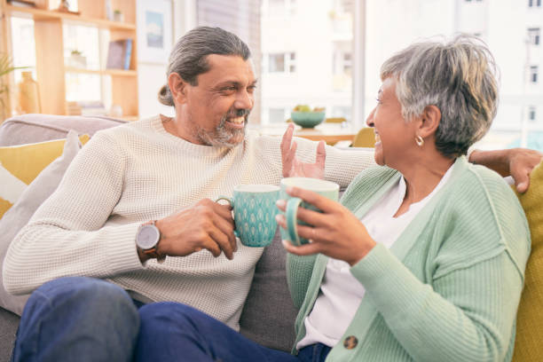 istock Coffee, conversation and mature couple on sofa for bonding, healthy relationship and connection. Marriage, love and happy man and woman drinking tea on couch to relax in discussion, talking and chat 1660911215