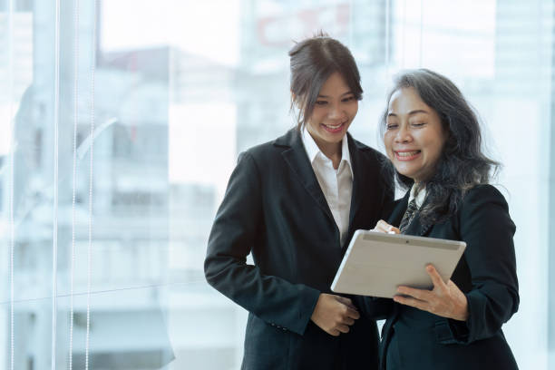 istock Two happy diverse coworker discussing report financial on tablet, working on project together 1660912483