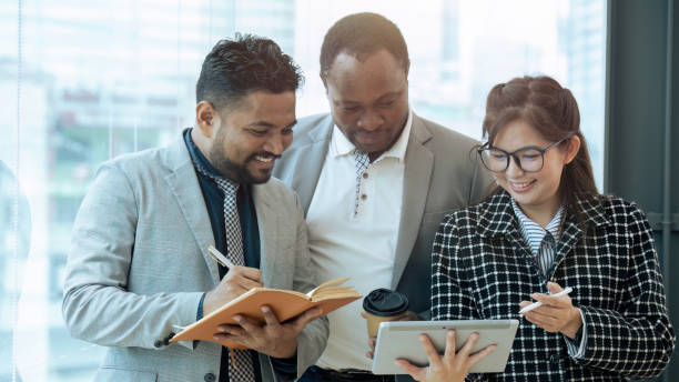 istock Happy diverse coworker discussing report on tablet, working on project together 1660913003
