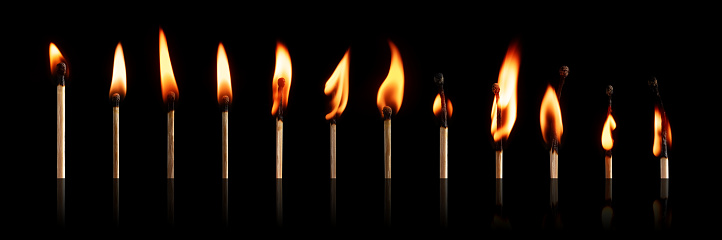 The stages of match burning on a black background. Safe match with red head. Different stages of matchstick burning. From Ignition to decay. Copy space, banner.