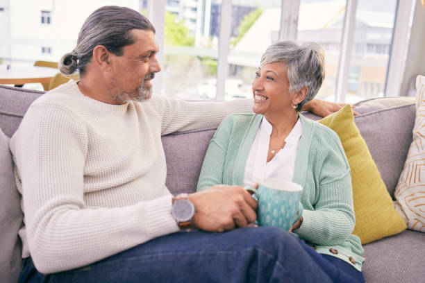istock Relax, conversation and mature couple on sofa for bonding, healthy relationship and connection with coffee. Marriage, love and happy man and woman drinking tea on couch in discussion, talking or chat 1660914127