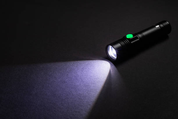 istock Flashlight and a beam of light in darkness. A modern led lamp with bright projection on dark table. 1660915127