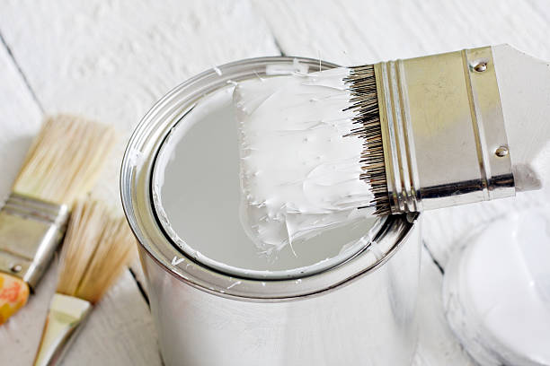 Paint brush and can on white planks