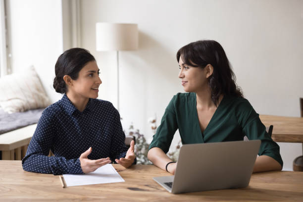 istock Two women coworkers working together, cooperate, engaged in teamwork 1660924487