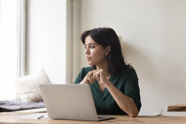 istock Serious woman sit at workplace desk with laptop starting aside 1660924492