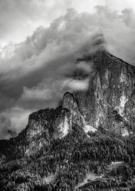 istock Vertical of a rocky mountain range in clouds in grayscale 1660928868