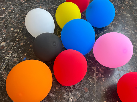 Different color balloons on the flooron the balcony on a sunny day close-up