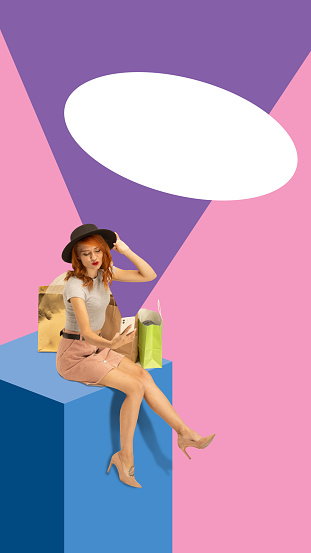 Contemporary art collage. Young stylishly dressed woman sitting on huge blue cube with bags, purchases near blank oval for text. Concept of Black Friday, shopping, big sales. Banner, copy space, ad