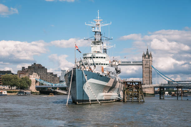 London, England - 29th July 2023: HMS Belfast, a 9 deck World War 2 navy warship, moored in front of Tower Bridge on the River Thames in London