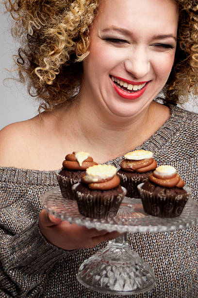 istock smiling laughing woman holding muffins 166100616