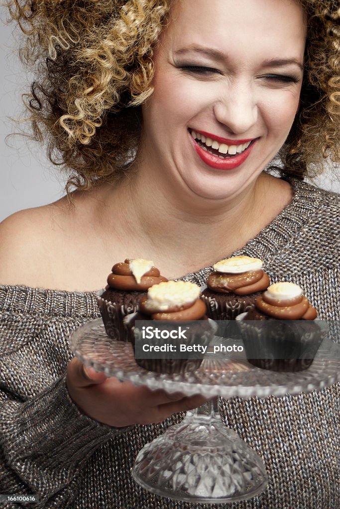 Sorrindo rindo mulher segurando muffins - Foto de stock de 30 Anos royalty-free