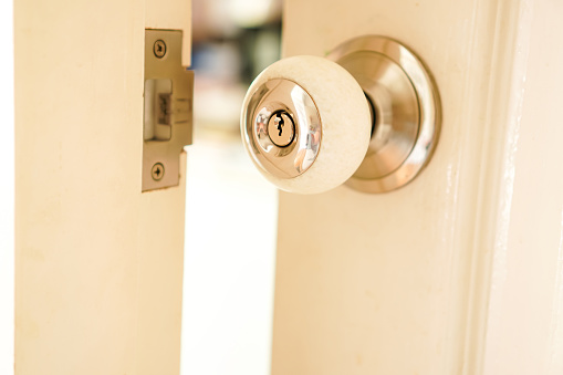 A close-up photo of a doorknob opening the door in a living room.