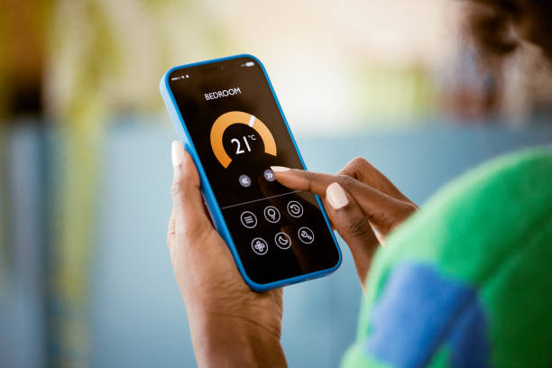 istock Woman using mobile phone to control termostat at home 1661021770