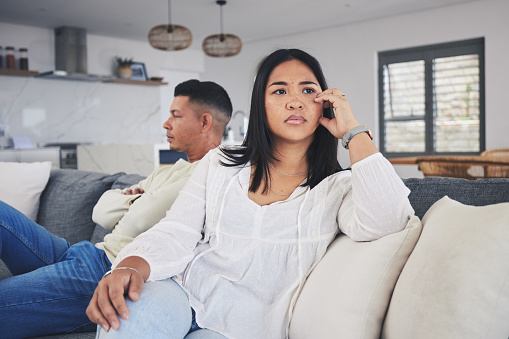 Frustrated couple, fight and conflict in divorce, argument or disagreement on living room sofa at home. Unhappy man and woman in breakup, cheating affair or dispute from toxic relationship in house