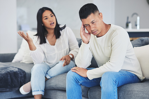 Frustrated couple, headache and disagreement in divorce, conflict or argument on living room sofa at home. Unhappy man and woman in breakup, cheating affair or fight from toxic relationship in house