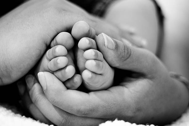 istock Mother holding his son feet 166103450