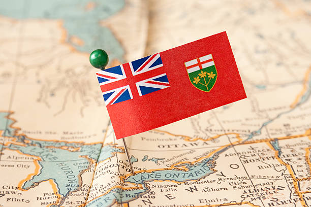 Ontario Ontario flag over more that sixty years old map pointing Toronto city. Shallow depth of field ontario flag stock pictures, royalty-free photos & images