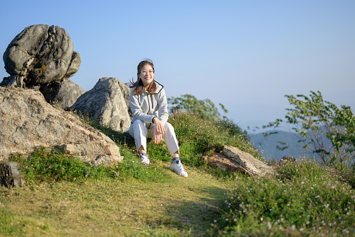 Young asian tourist hiking at Doi mon-jan enjoying the nature sitting on mountain peak enjoy the sunrise