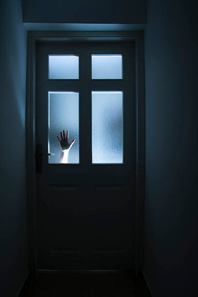 istock A door with a hand against the glass for help 166108089
