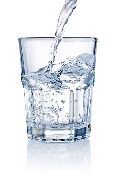 Water pouring into glasses isolated on a white background Water pouring into glasses isolated on a white background whites only drinking fountain stock pictures, royalty-free photos & images
