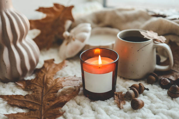 istock Burning candle with label isolated in autumn interior 1661091335