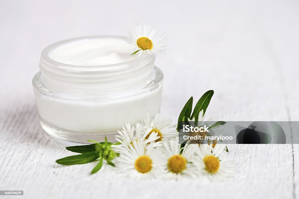 cream and chamomiles container with cream and chamomiles on white wooden background Beauty In Nature Stock Photo