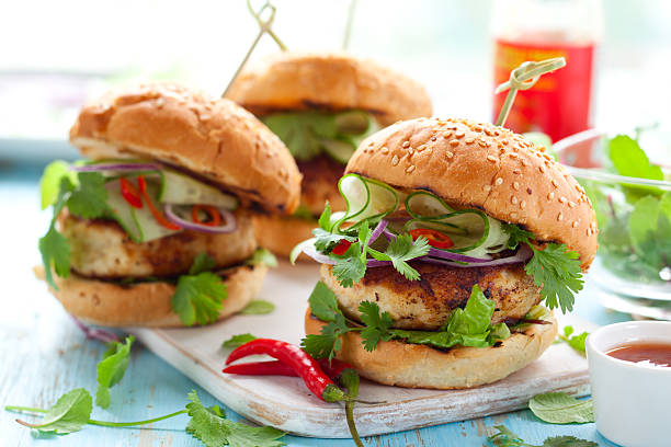 Thai chicken burger Thai chicken burger with cucumber and sweet chilli sauce chicken burger no bun stock pictures, royalty-free photos & images