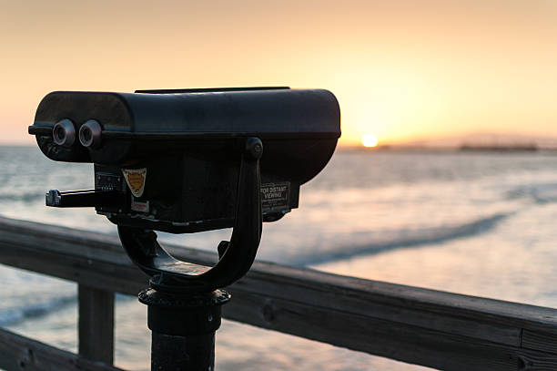 istock Coin-operated binoculars on pier at sunset overlooking ocean 166110076