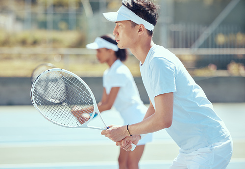 Asian tennis man with racket and training, practice or play game on a court. Serious, focused fitness athletes together playing competitive double match as team to stay fit and healthy in sports club