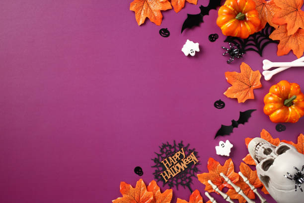 istock Halloween flat lay composition. Orange maple leaves, pumpkins, skull, ghosts, bats, skeleton hands on purple background. Top view with copy space. 1661102738